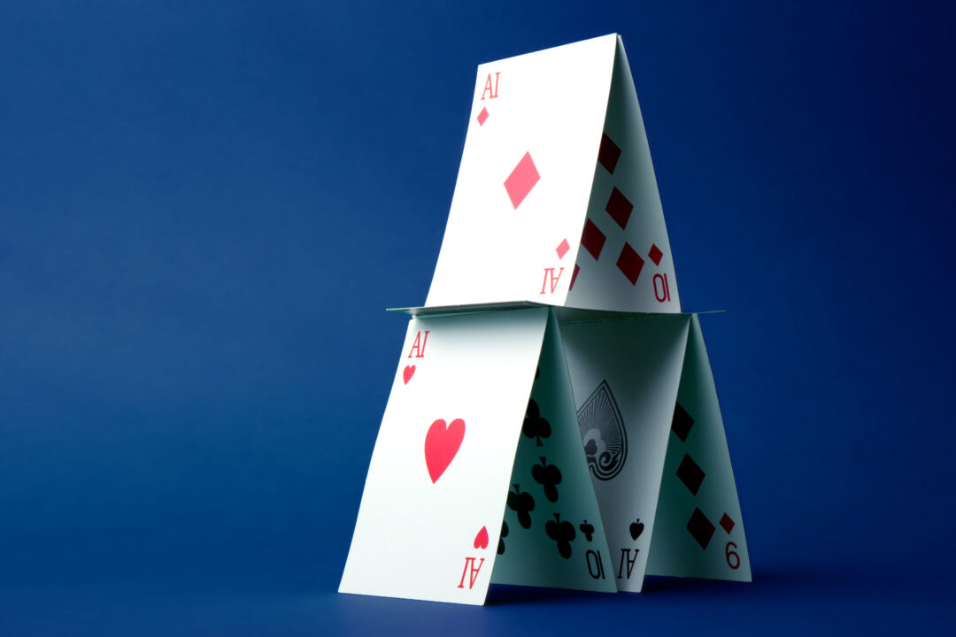 House of cards made of standard playing cards with the text "AI" replacing numbers