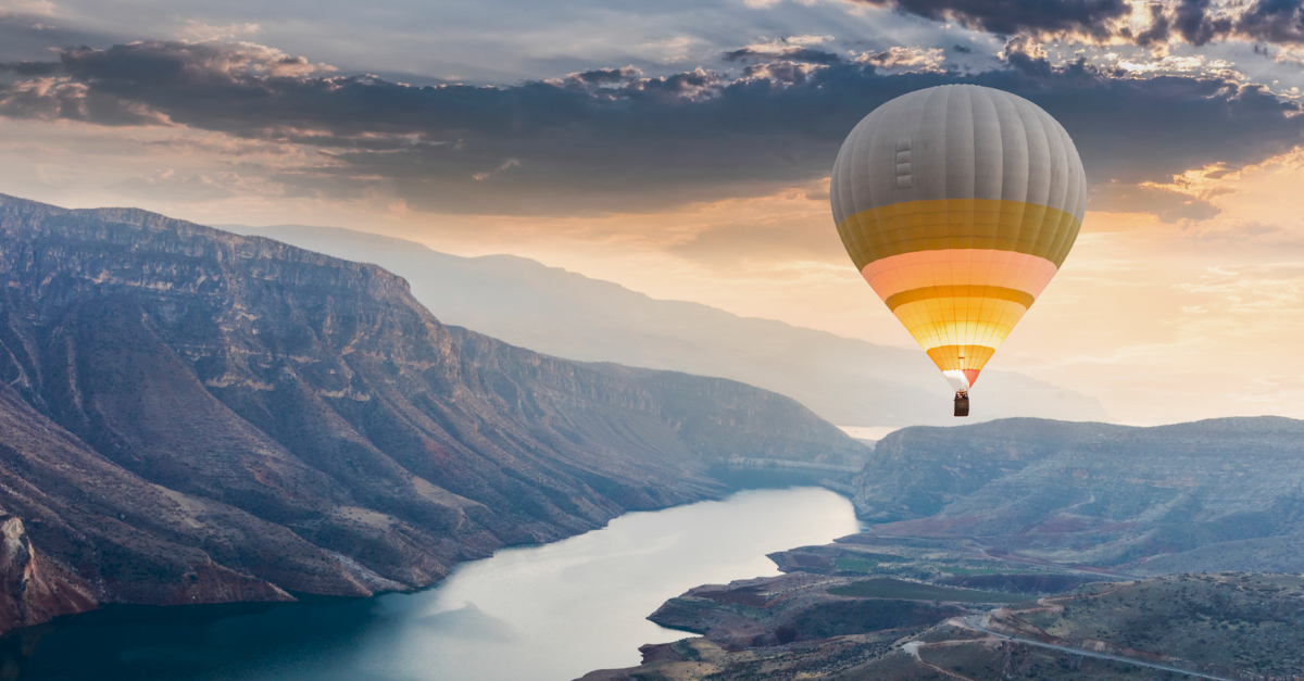 Hot Air Balloon floats over windy river