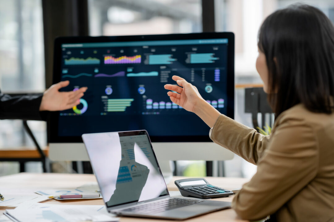 People looking at a monitor showing data visualizations